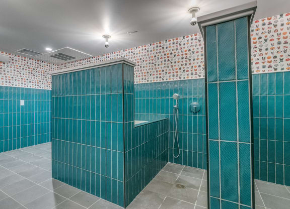 a stall in a bathroom with blue tiles