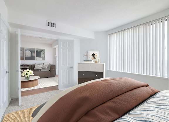 a bedroom with a bed and a living room with a couch