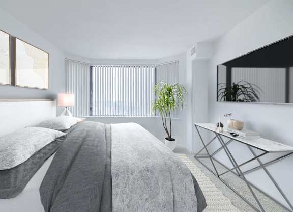 a white bedroom with a bed and a potted plant
