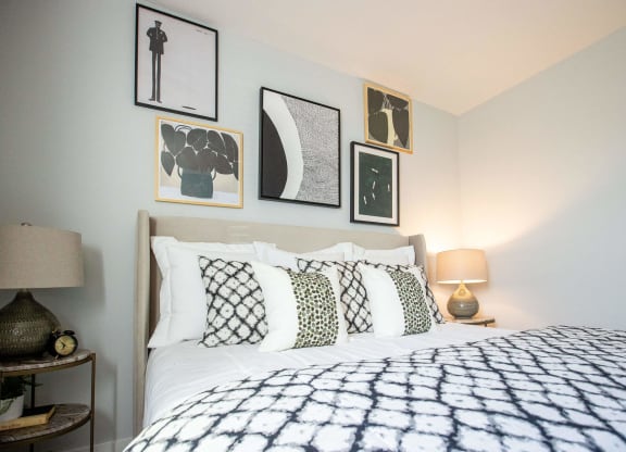 a bedroom with a bed and framed pictures on the wall