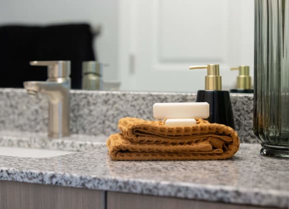 a bathroom with a soap dispenser and a towel on a sink
