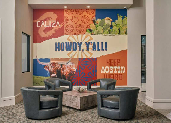 a lobby with chairs and a mural on the wall