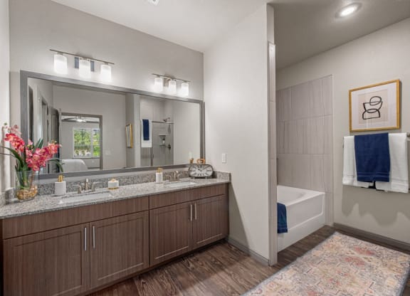 A bathroom with a double vanity and large soaking tub