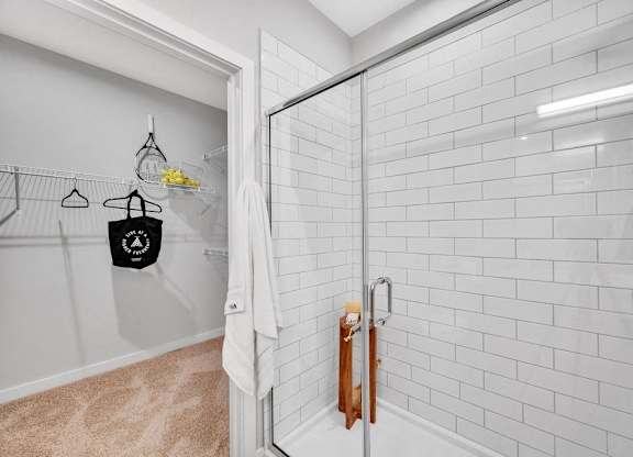 a white bathroom with a shower with a glass door