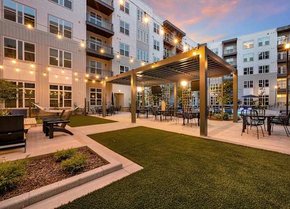 an outdoor patio with tables and chairs at an apartment complex