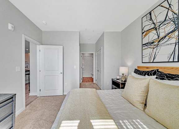 a bedroom with a large bed and a door to a bathroom