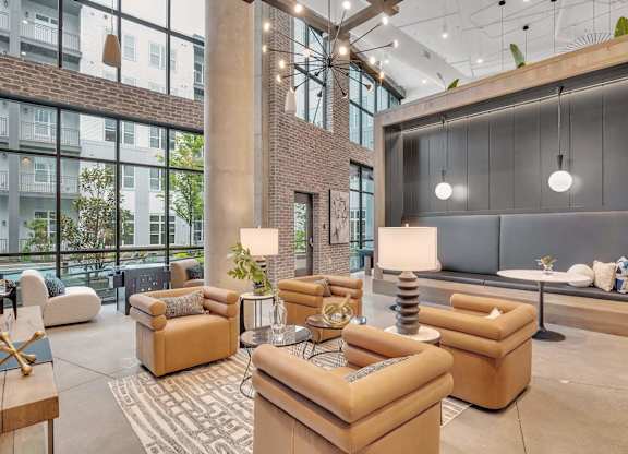 a lobby with couches and chairs and a large wall of windows