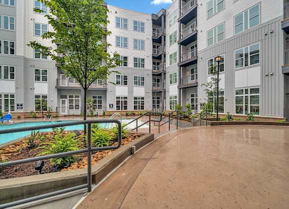 an empty courtyard with an apartment building and a pool