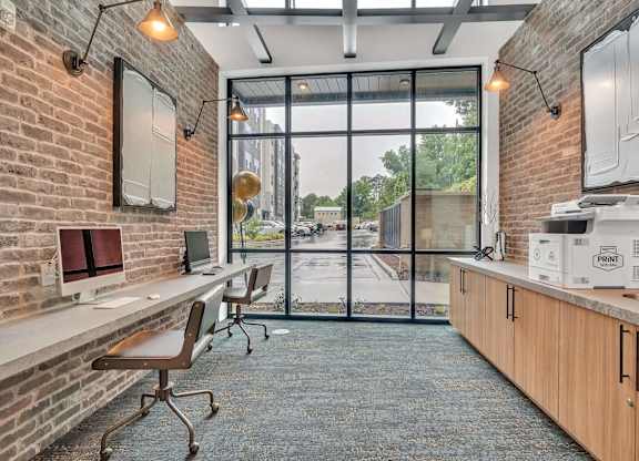 an office with a brick wall and a large window