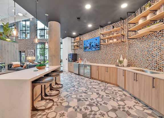 a kitchen with a long counter and stools in a lobby