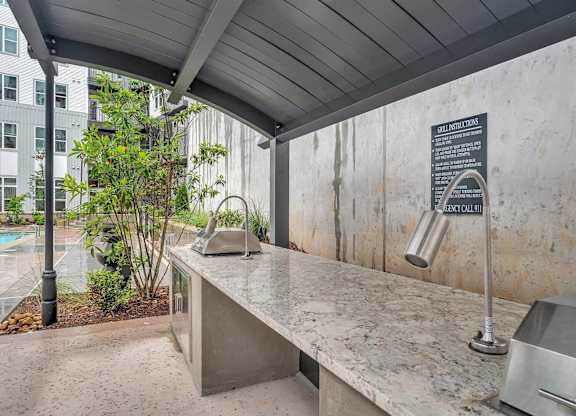 the kitchen has a concrete countertop and a sink with a large counter