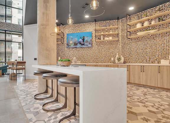 a restaurant with a white counter and stools in a lobby
