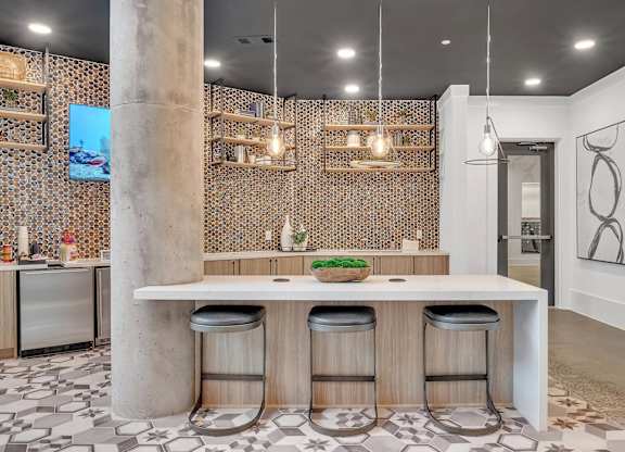a tasting room with a long counter with black chairs