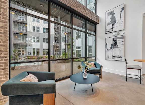 a living room with large windows and a blue coffee table