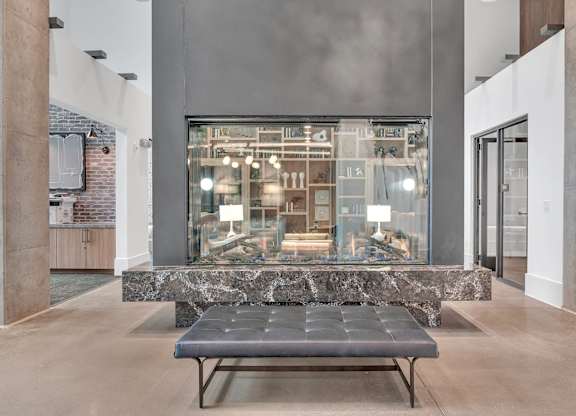 a large glass display case in a lobby with a bench