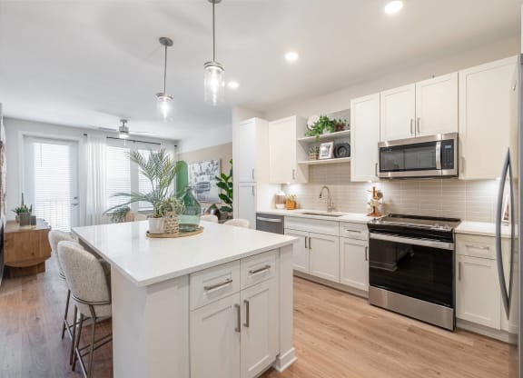 an open kitchen with white cabinets and stainless steel appliances