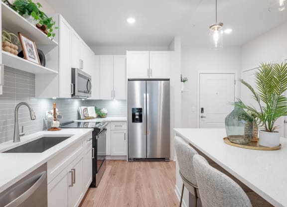 a kitchen with white cabinets and a stainless steel refrigerator