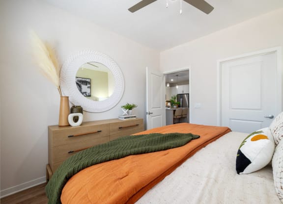 a bedroom with a bed and a mirror on the wall