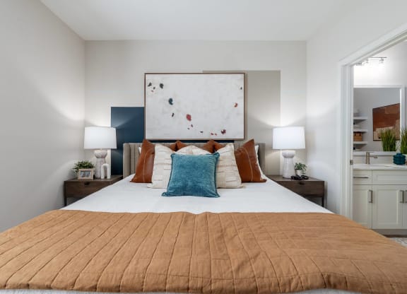 a bedroom with a large bed and a painting on the wall