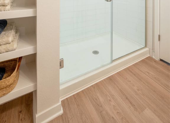 a walk in shower with a glass door in a bathroom