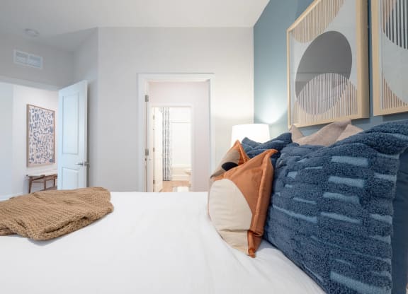 a bedroom with a large bed and a mirror on the wall