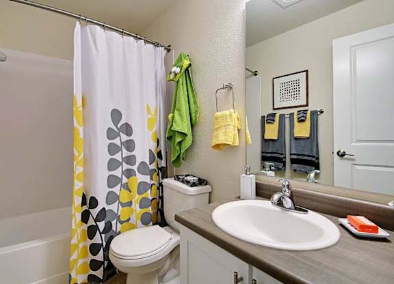 Bathroom with patterned shower curtain and modern fixtures at Hidden River Townhomes Apartments, Kirkland, WA