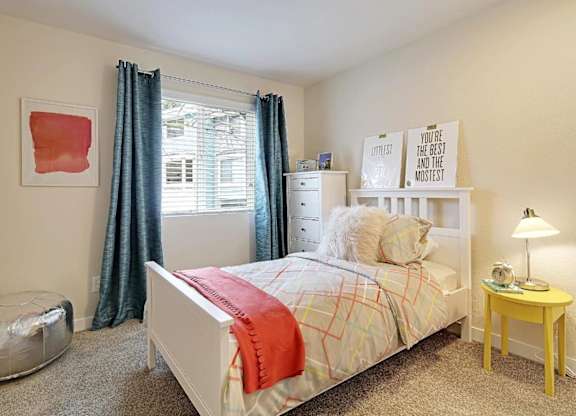 Bright bedroom with white furniture and yellow nightstand at Hidden River Townhomes Apartments, Kirkland, Washington