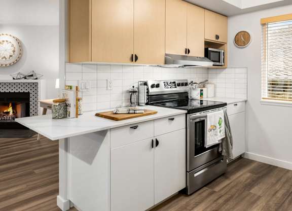 Kitchen with white cabinets and stainless steel appliances at Scout Apartments, Kirkland, WA 98034