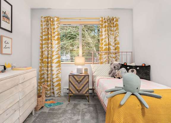 Childs bedroom with yellow accents and stuffed animals at Scout Apartments, Kirkland, 98034