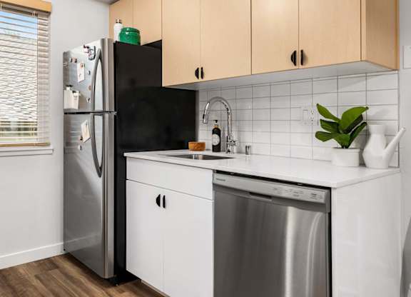 Compact kitchen with white tile backsplash and dishwasher at Scout Apartments, Kirkland, 98034