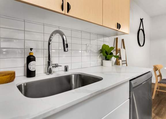 Modern kitchen with white countertops and subway tile backsplash at Scout Apartments, Kirkland, Washington