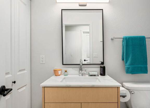 Bathroom vanity with framed mirror and towel bar at Scout Apartments, Washington, 98034