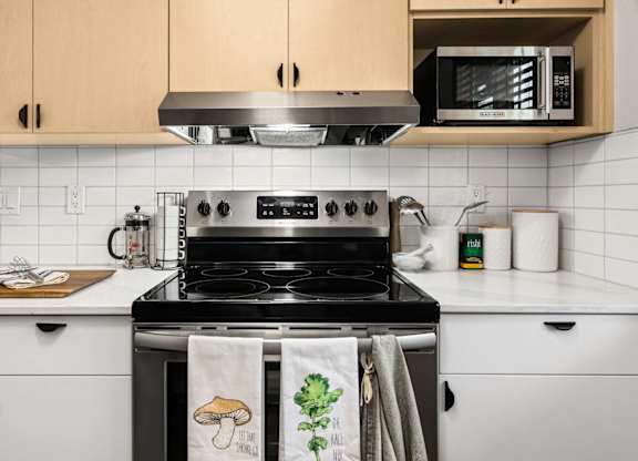Kitchen with stainless steel stove and white countertops at Scout Apartments, Kirkland, WA 98034