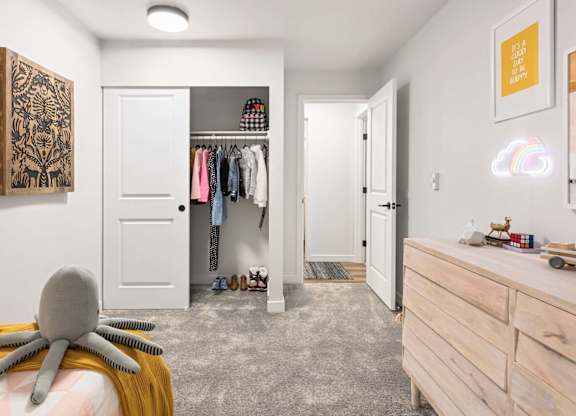 Childs bedroom with open closet and light wood dresser at Scout Apartments, Kirkland, 98034