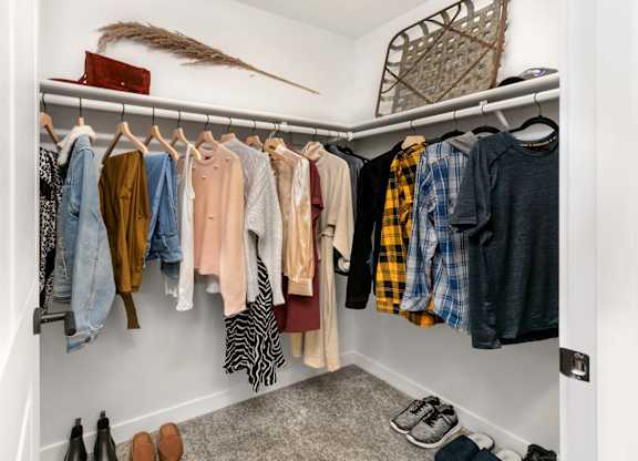 Walk-in closet with organized clothing storage at Scout Apartments, Washington, 98034