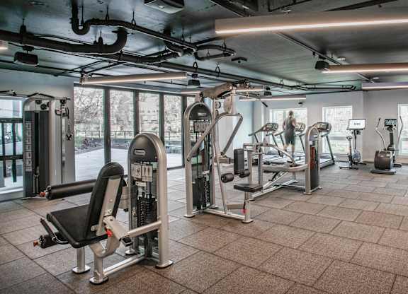 A gym with a variety of equipment including treadmills, weights, and exercise machines.at Axle, Seattle, WA 