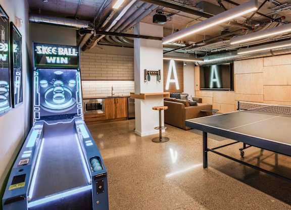 A room with a ping pong table and a bowling alley simulator.at Axle, Seattle Washington 