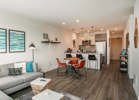 A modern living room with a grey sofa and a wooden dining table.at Axle, Washington, 98119