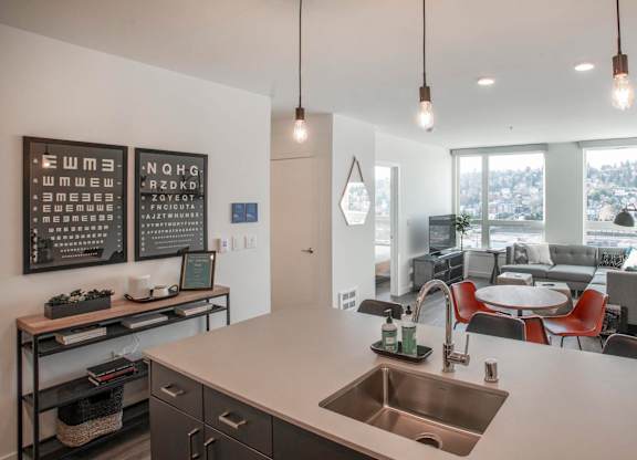 A modern kitchen with a large island and pendant lights.at Axle, Seattle, 98119 