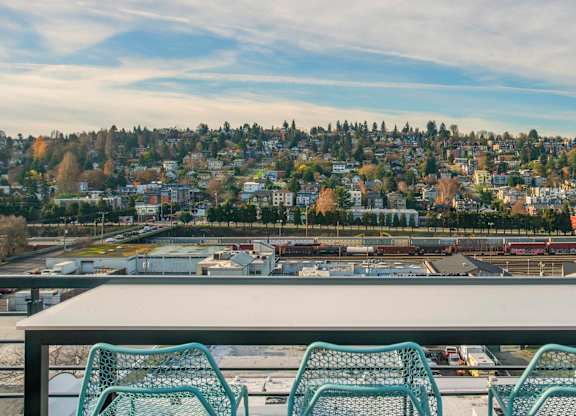 A table with four chairs is in front of a scenic view of a city.at Axle, Seattle 