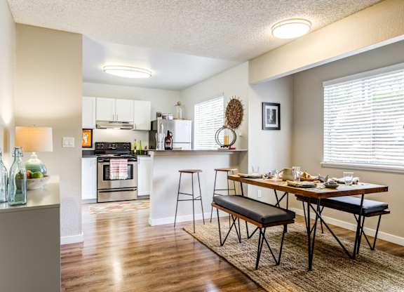 A kitchen with a table and chairs in front of it.