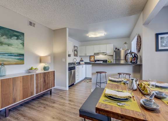 A modern kitchen with a dining table set for a meal.