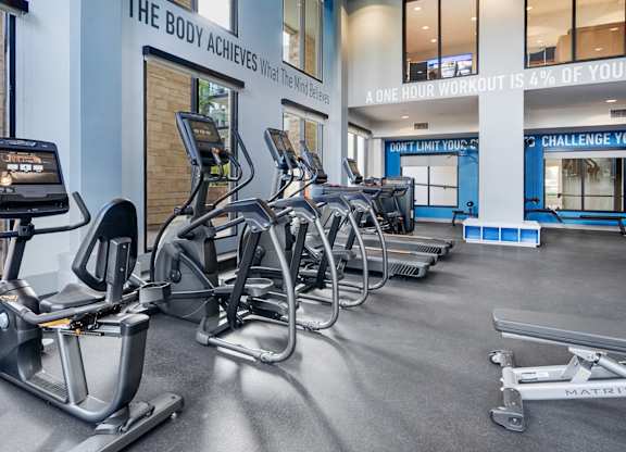 A gym with a row of exercise bikes and a sign that says