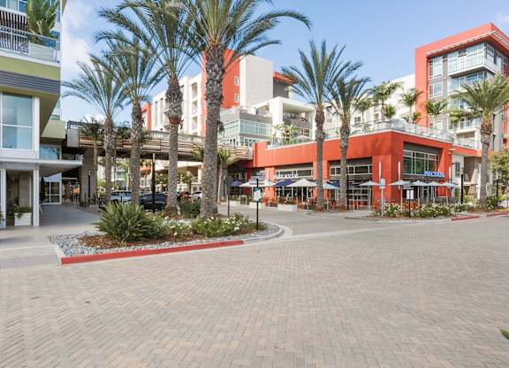 A shopping center with palm trees in front.