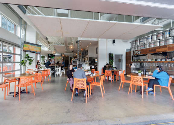 A group of people are sitting at tables in a brightly lit restaurant.