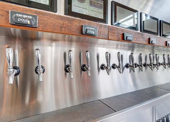 A stainless steel beer tap line with a wooden board above it.