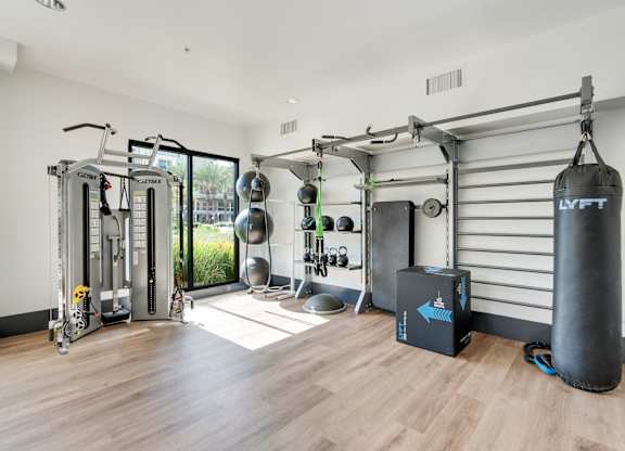 A gym with a punching bag and a variety of exercise equipment.