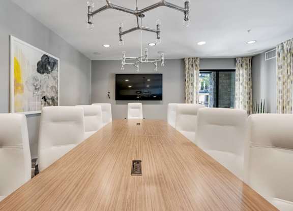 A conference room with a long table and chairs.