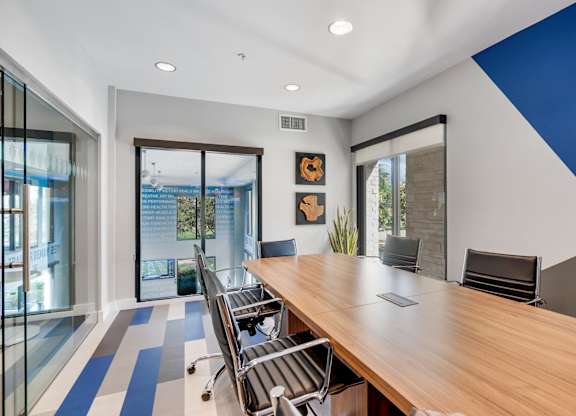 A conference room with a long table and chairs.