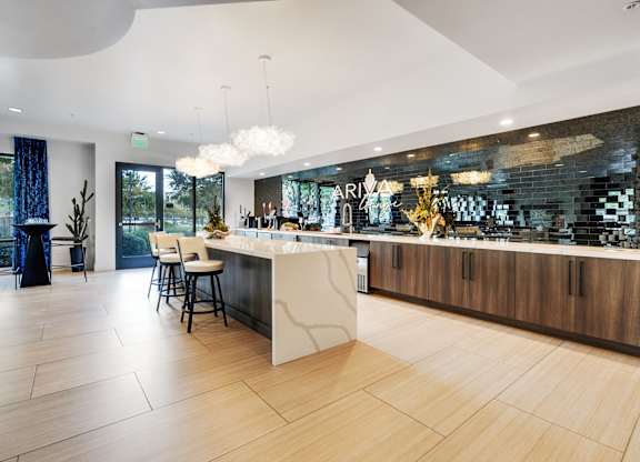 A modern kitchen with a bar area and a dining table.